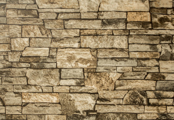 gray brown stone wall of bricks of various shapes and sizes. rough surface texture