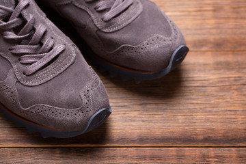 Sneakers on the wooden floor top view. Brogue sneakers on wooden background.