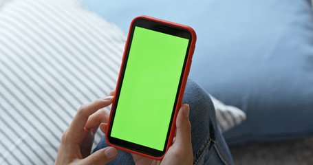 Woman hold with mobile phone with green screen