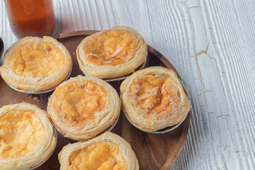 close up of egg tarts on wooden plate