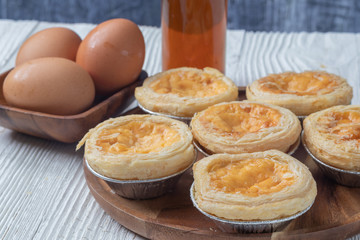 close up of egg tarts on wooden plate