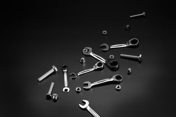 Nuts, bolts, tool wrench, ratchet on a dark background.