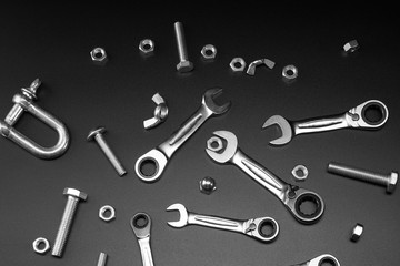 Nuts, bolts, tool wrench, ratchet on a dark background.