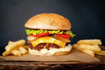  Delicious homemade hamburger with beef, lettuce, cheese, cucumber and french fries  on stone background