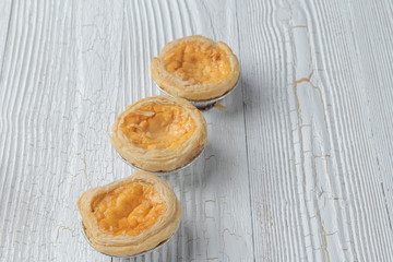 close up of egg tarts on wooden plate