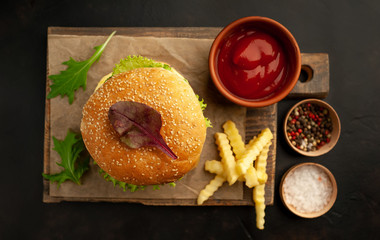  Delicious homemade hamburger with beef, lettuce, cheese, cucumber and french fries  on stone background, top view