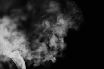 White smoke on a black background. Texture of smoke. Clubs of white smoke on a dark background for an overlay