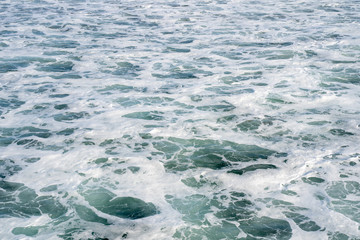 Fototapeta na wymiar Sea foam and waves of the Pacific Ocean on the California Coast. Abstract, useful for backgrounds