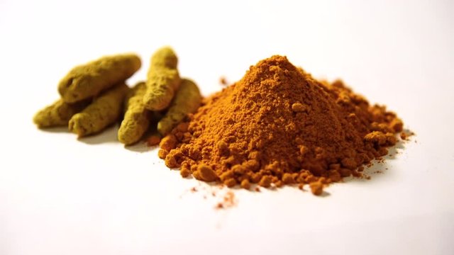 Turmeric (Curcuma) or haldi powder pile footage, isolated on white background