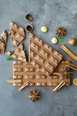 A bar of milk chocolate on the table. Chocolate with nuts and cinnamon.