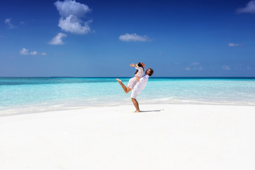 Fototapeta na wymiar Glückliches Paar genießt seinen Urlaub am tropischen Strand mit türkisem Meer und blauem Himmel