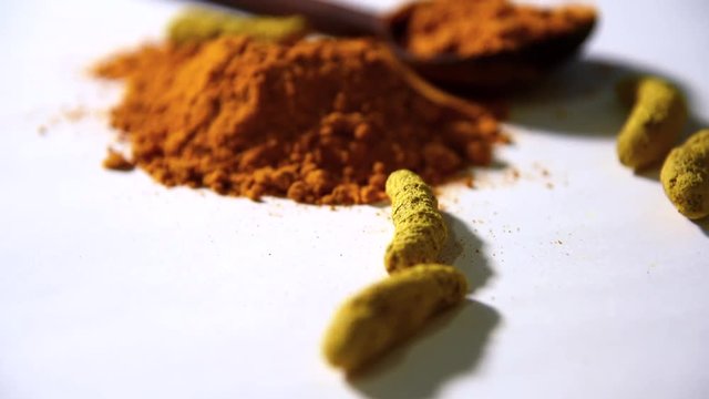 Turmeric (Curcuma) or haldi powder pile footage, isolated on white background