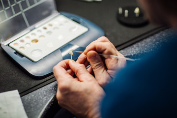 dentist works on tooth crown in dental laboratory. medical concept.