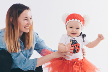 baby in the arms of the mother. on white background Woman holding a child. Fashion for girl.