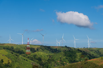 Fototapeta na wymiar Wind turbines farm on the mountains; blue sky, white clouds