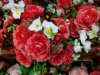 Background of Red Artificial Roses and Other White Flowers with Selective Focus