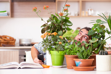 Young handsome man cultivating flowers at home