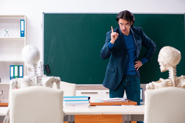 Male teacher and skeleton student in the classroom 