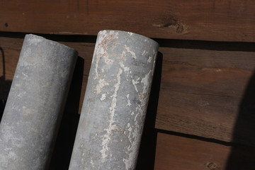 white and grey asbestos pipes by the wooden brown wall