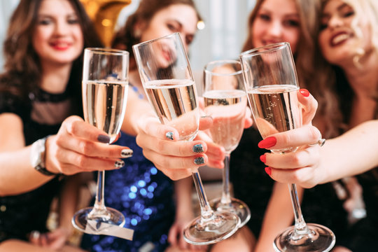 Girls party. Closeup of glasses with champagne. Young ladies celebrating special occasion, having fun together.