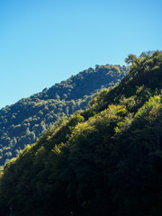 Naklejka premium The Green slope of the mountain, illuminated by the sunset Sun.