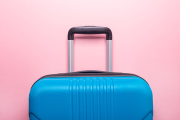 Blue suitcase on pastel pink background Creative Summer holidays, vacation, travel concept