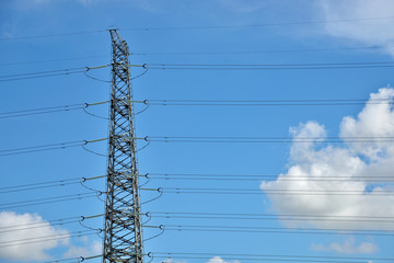 High voltage towers in the blue sky white cloud background
