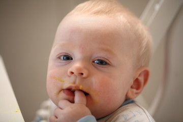 A child of 6 months pedagogical feeding from a spoon of porridge.