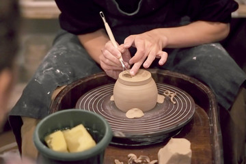 The hands of the master working with clay on a potter's wheel, close-up