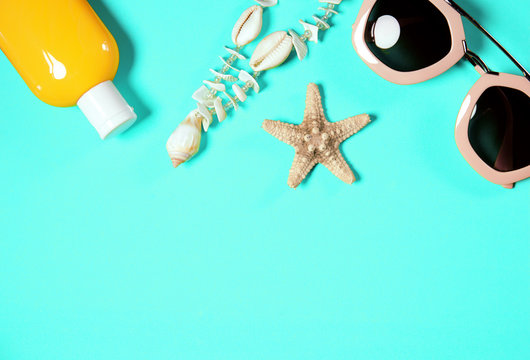 Beach accessories on a bright green colorful background. Dried starfish, shells necklace. Image is with copy space