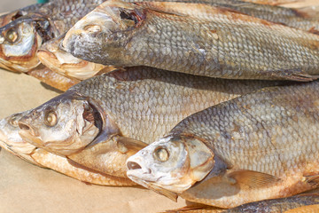 Dried fish with salted scales on packaging paper, close-up