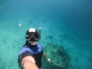 freediver taking selfie at a very great depth close to bottom of the sea