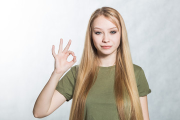 Fototapeta premium Young beautiful woman shows ok sign. Body language concept.