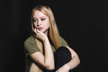 Fototapeta premium Sad young woman going to cry in a black background
