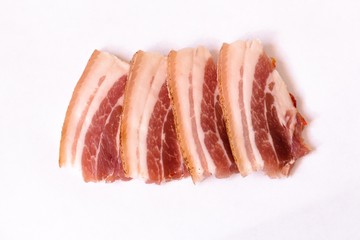 Several fresh and juicy bacon slices lie on a white neutral background. Bacon is ready for use in writing for many dishes.