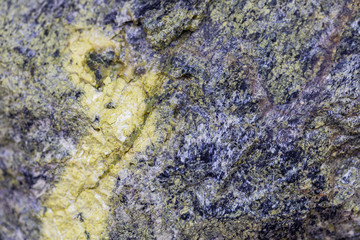 The structure of a stone of green color damaged by bad weather with moss-grown. Ready photo background. Soft focus. Macro.