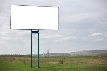 Empty billboard blank for advertising in green field.
