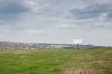 Empty billboard blank for advertising in green field.