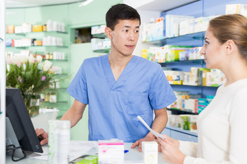 Adult woman is asking pharmacist about medicines