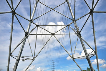 Fototapeta premium High voltage towers in the blue sky white cloud background