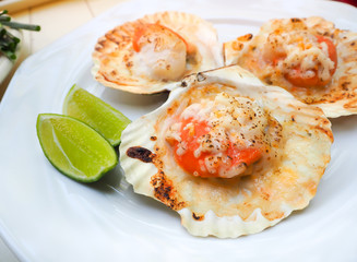 Grilled scallops shell with butter and cheese. Thai seafood grilled scallops on white plate.