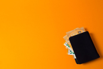 black wallet with euro money on a yellow background - obrazy, fototapety, plakaty