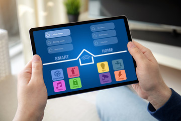man hands holding computer tablet with app smart home