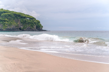 Waves breaking on a white sand 