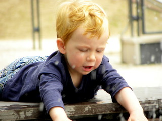 little boy playing with water