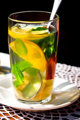 Fruit orange tea with mint, ginger and cinnamon. Orange slices in a glass cup close up