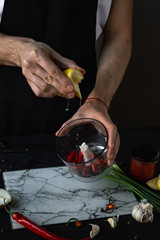 Adding fresh lemon juice to a chili pepper salsa. Cooking in a hand blender.