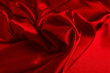 Red silk or satin luxury fabric texture can use as abstract background. Top view.