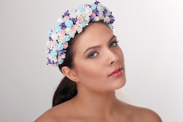 Beauty portrait of brunette woman in beautiful flower wreath on her head.