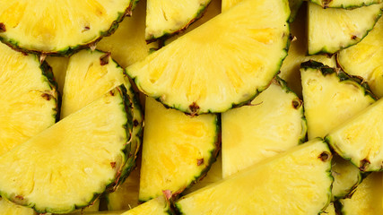 Pineapple juicy yellow slices background. Top view.